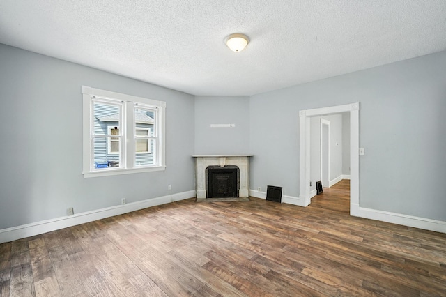 870 Clark St, Saint Paul, MN 55130 - unfurnished living room with wood finished floors, a fireplace, and a textured ceiling