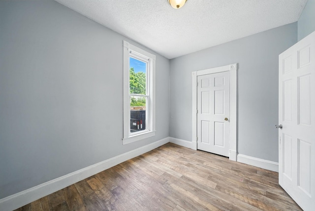 870 Clark St, Saint Paul, MN 55130 - unfurnished bedroom featuring wood finished floors and a textured ceiling