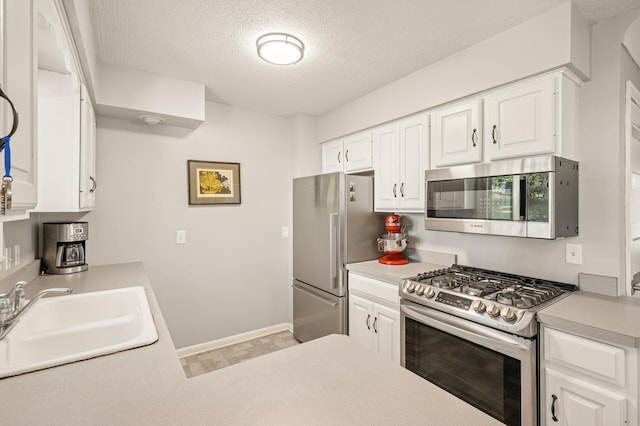 3420 Parkview Blvd, Robbinsdale, MN 55422 - kitchen featuring stainless steel appliances, a textured ceiling, light countertops, and white cabinetry
