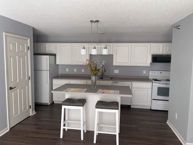 2012 11th Ave SE Unit B, Rochester, MN 55904 - kitchen with appliances with stainless steel finishes, a textured ceiling, white cabinetry, dark wood-style floors, and a center island