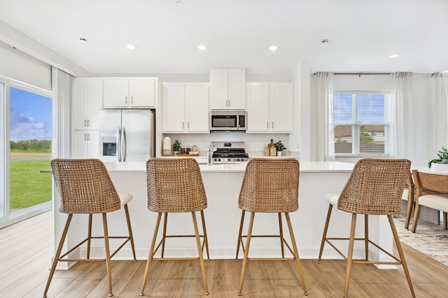 5413 Queens Dr NW, Rochester, MN 55901 - kitchen with stainless steel appliances, a spacious island, light countertops, light wood finished floors, and recessed lighting