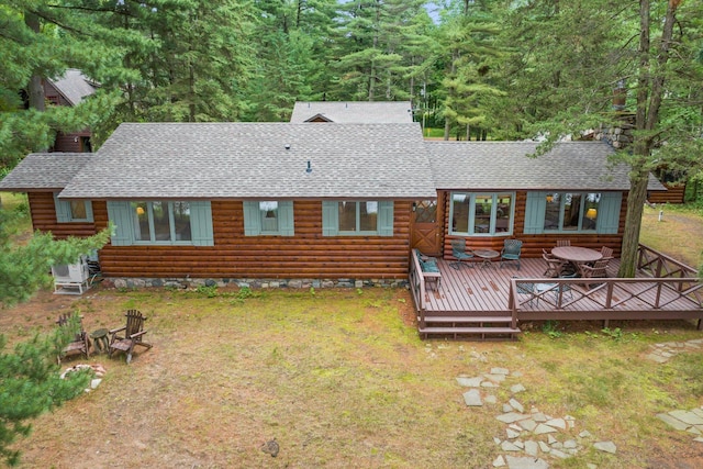 25761 Echo Bay Rd, Bay Lake Twp, MN 56444 - back of property with roof with shingles, a wooden deck, log exterior, a lawn, and a chimney