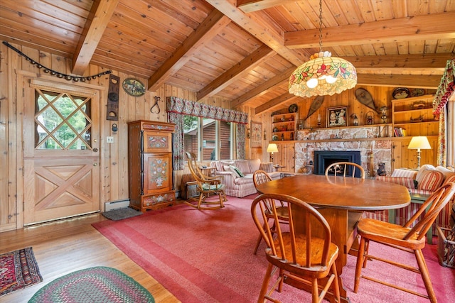 25761 Echo Bay Rd, Bay Lake Twp, MN 56444 - dining space featuring wooden ceiling, wooden walls, wood finished floors, and a stone fireplace