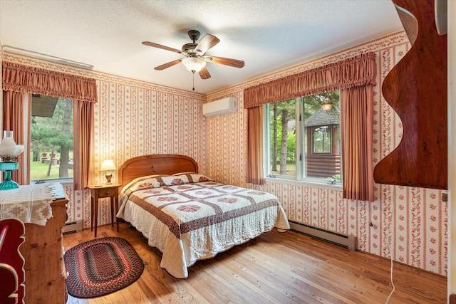 25761 Echo Bay Rd, Bay Lake Twp, MN 56444 - bedroom with a baseboard heating unit, a wall mounted air conditioner, wood-type flooring, wallpapered walls, and multiple windows