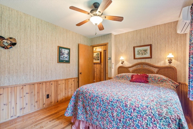 25761 Echo Bay Rd, Bay Lake Twp, MN 56444 - bedroom with wallpapered walls, wood finished floors, a wall mounted AC, and ceiling fan