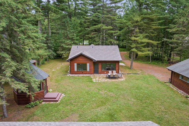 25761 Echo Bay Rd, Bay Lake Twp, MN 56444 - back of property featuring faux log siding, a shingled roof, a lawn, a deck, and a wooded view