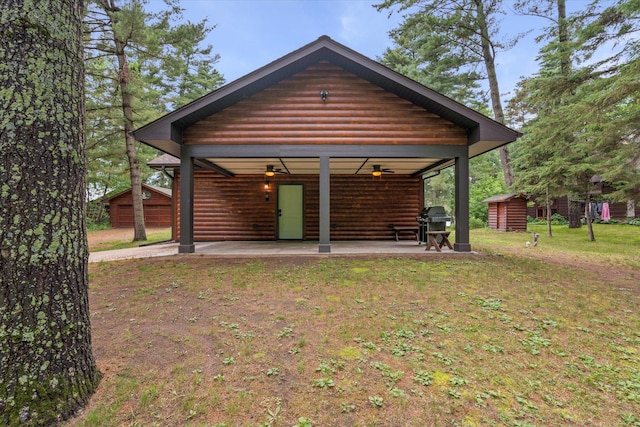 25761 Echo Bay Rd, Bay Lake Twp, MN 56444 - rear view of house with a patio area, a storage shed, faux log siding, a yard, and a ceiling fan