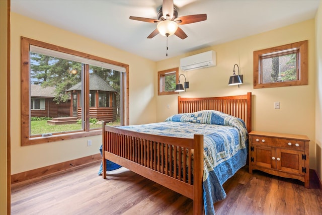 25761 Echo Bay Rd, Bay Lake Twp, MN 56444 - bedroom featuring an AC wall unit, multiple windows, and wood finished floors