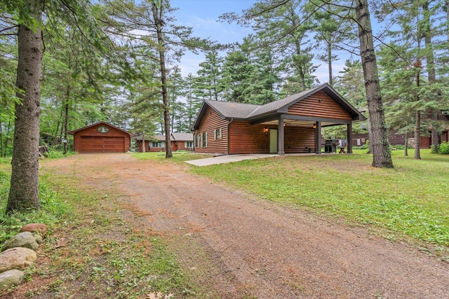 25761 Echo Bay Rd, Bay Lake Twp, MN 56444 - view of front of home with driveway, an outdoor structure, a garage, log veneer siding, and a front yard
