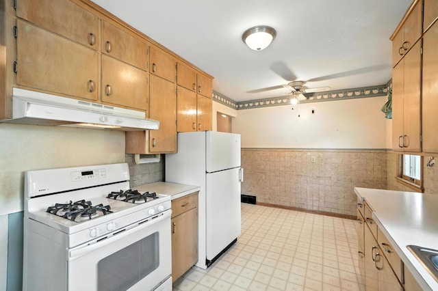8775 County Road 10 E, Waconia, MN 55387 - kitchen with white appliances, under cabinet range hood, wainscoting, a ceiling fan, and light countertops