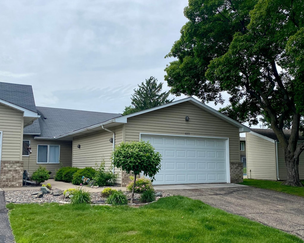 6333 Vera Cruz Ln N, Brooklyn Park, MN 55429 - ranch-style home featuring asphalt driveway, a garage, a front lawn, and roof with shingles