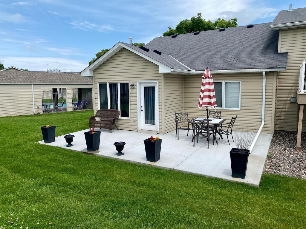 6333 Vera Cruz Ln N, Brooklyn Park, MN 55429 - rear view of house with a lawn, a patio, and a shingled roof