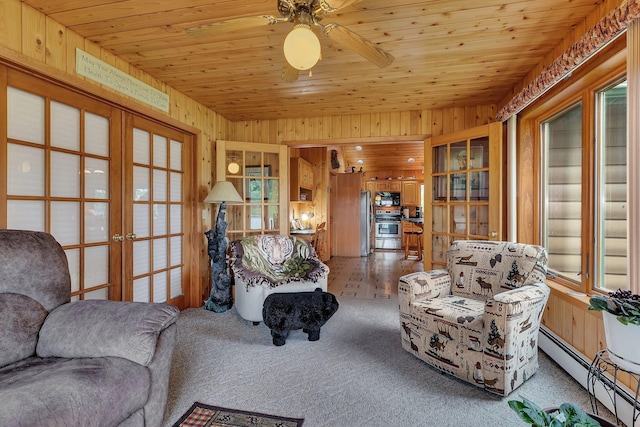 38071 248th St, Hillman, MN 56338 - living area with a baseboard heating unit, french doors, wooden walls, wood ceiling, and a ceiling fan