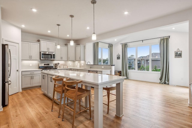 146 Maple Ter, Waconia, MN 55387 - kitchen with stainless steel appliances, backsplash, a center island, light wood-style flooring, and recessed lighting