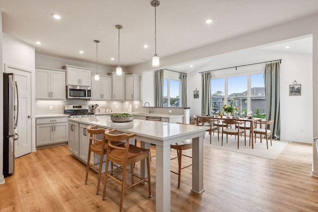 146 Maple Ter, Waconia, MN 55387 - kitchen featuring stainless steel appliances, backsplash, light countertops, a kitchen bar, and recessed lighting