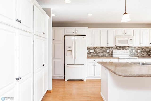 210 1st St, Arthur, ND 58006 - kitchen with white appliances, white cabinets, light wood-style floors, hanging light fixtures, and decorative backsplash