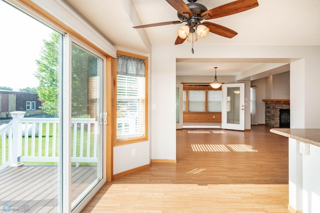 210 1st St, Arthur, ND 58006 - interior space featuring healthy amount of natural light, light wood-style flooring, ceiling fan, a stone fireplace, and lofted ceiling