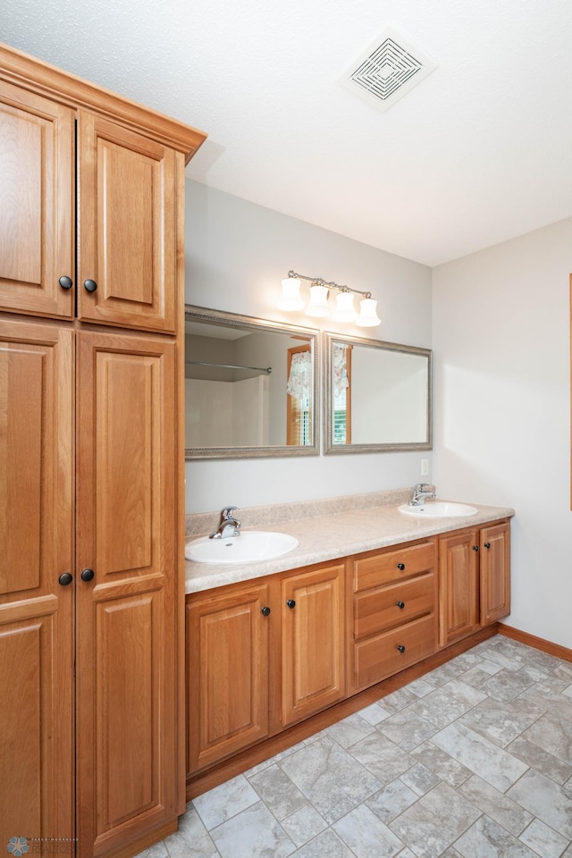 210 1st St, Arthur, ND 58006 - bathroom featuring double vanity and stone finish flooring