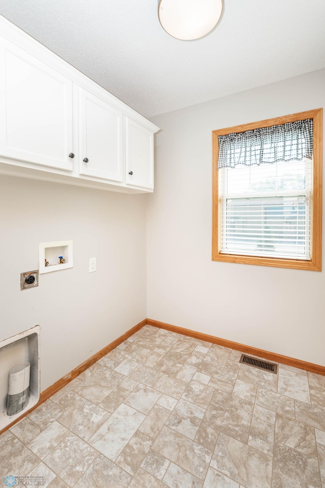 210 1st St, Arthur, ND 58006 - laundry area with cabinet space, electric dryer hookup, washer hookup, and stone finish flooring