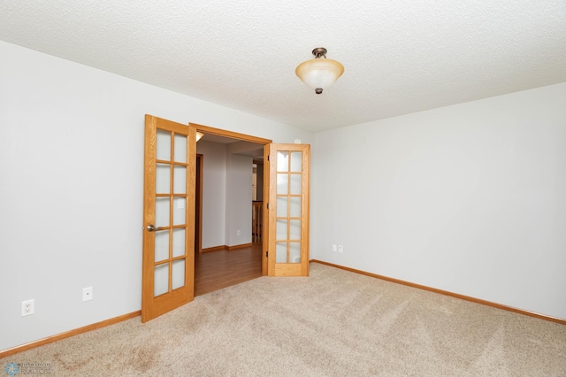 210 1st St, Arthur, ND 58006 - empty room featuring french doors, carpet, and a textured ceiling