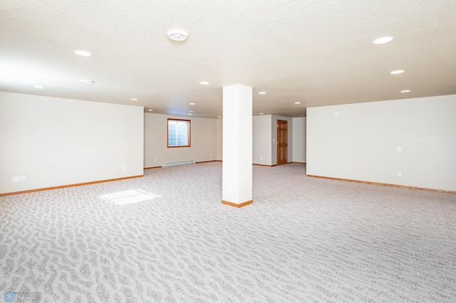 210 1st St, Arthur, ND 58006 - basement with recessed lighting, light colored carpet, a baseboard heating unit, and a textured ceiling