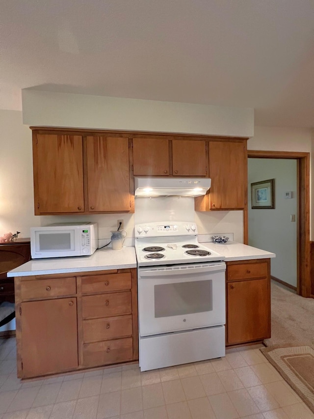 1804 7th St SW, Willmar, MN 56201 - kitchen with white appliances, under cabinet range hood, light countertops, and brown cabinets