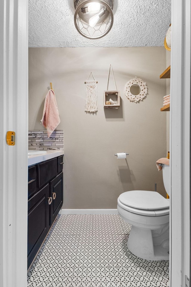 721 1st St N, Waterville, MN 56096 - bathroom with vanity, a textured ceiling, and decorative backsplash