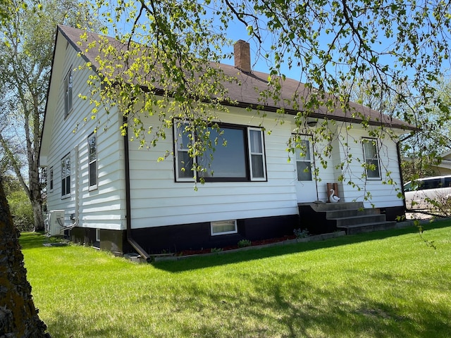 912 3rd St NE, Roseau, MN 56751 - view of front of property with a chimney, a front yard, and a shingled roof