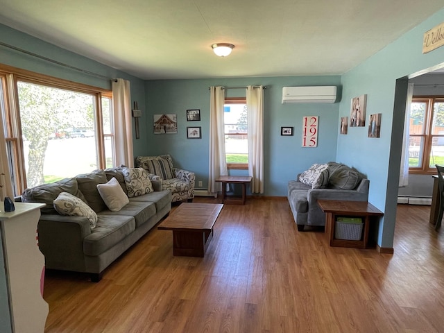 912 3rd St NE, Roseau, MN 56751 - living room featuring a wall mounted air conditioner, baseboard heating, and wood finished floors