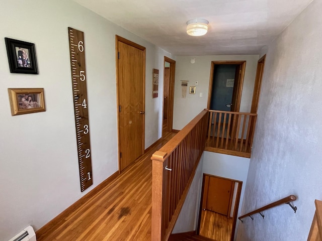 912 3rd St NE, Roseau, MN 56751 - corridor featuring an upstairs landing, baseboard heating, and wood finished floors