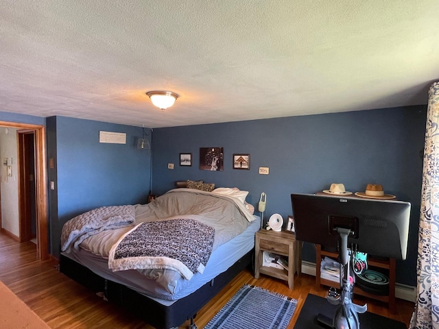912 3rd St NE, Roseau, MN 56751 - bedroom featuring wood finished floors and a textured ceiling
