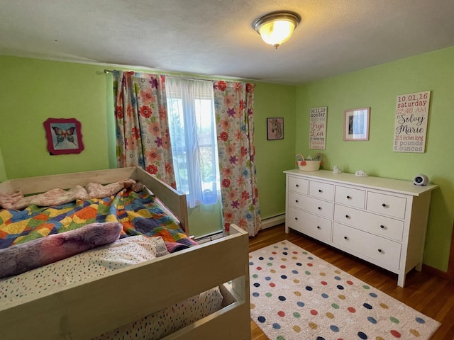 912 3rd St NE, Roseau, MN 56751 - bedroom featuring dark wood-style flooring and a baseboard radiator