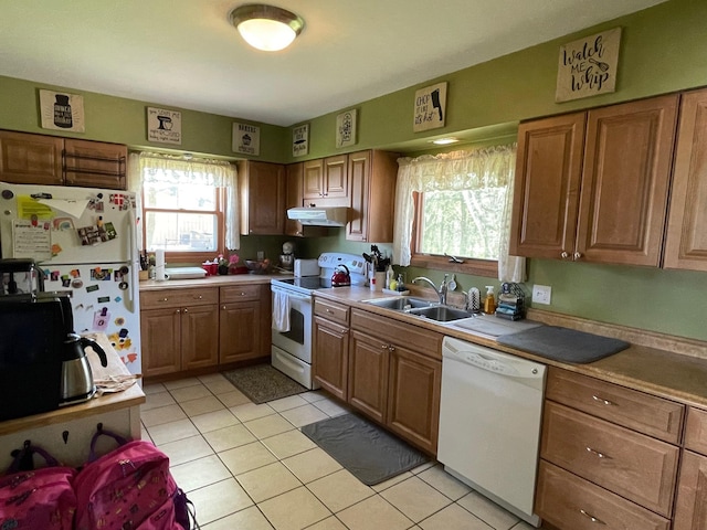 912 3rd St NE, Roseau, MN 56751 - kitchen with white appliances, under cabinet range hood, plenty of natural light, and brown cabinetry