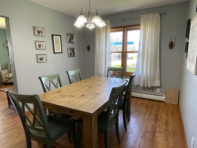 912 3rd St NE, Roseau, MN 56751 - dining space with a baseboard heating unit, wood finished floors, and a chandelier