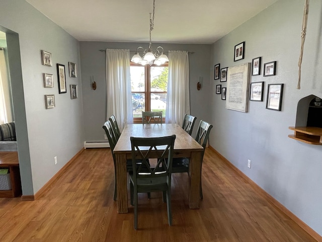 912 3rd St NE, Roseau, MN 56751 - dining room featuring a baseboard radiator, a chandelier, and wood finished floors