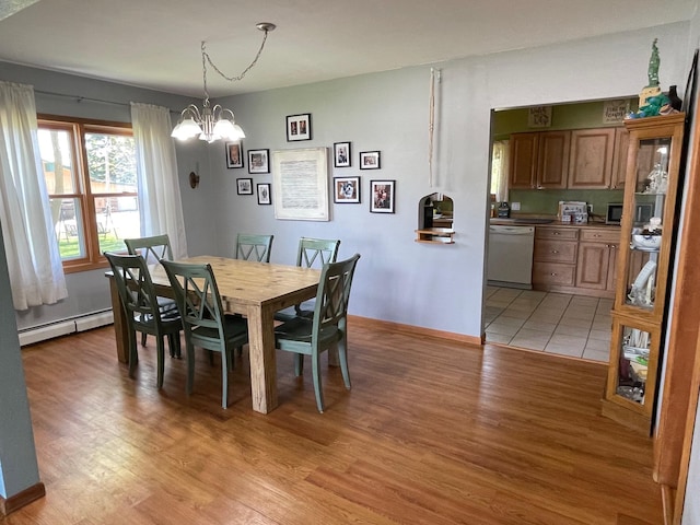 912 3rd St NE, Roseau, MN 56751 - dining area with baseboard heating, light wood-style floors, and a chandelier