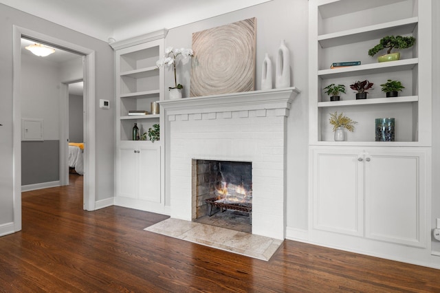 6045 Oakland Ave, Minneapolis, MN 55417 - unfurnished living room with dark wood-type flooring, built in shelves, and a brick fireplace