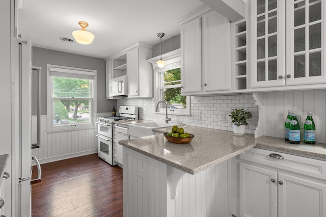 6045 Oakland Ave, Minneapolis, MN 55417 - kitchen featuring white appliances, white cabinets, a peninsula, a wainscoted wall, and dark wood-style flooring