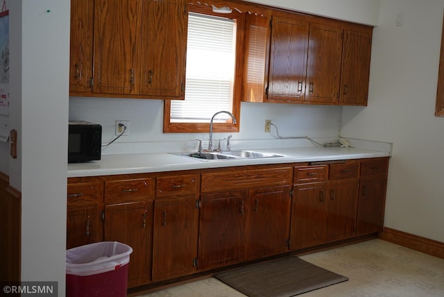 653 Thomas Ave, Saint Paul, MN 55104 - kitchen with black microwave, light countertops, light floors, and brown cabinetry