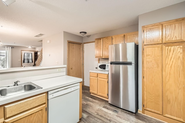 2225 Ranchview Ln N Unit 5, Plymouth, MN 55447 - kitchen featuring white appliances, light wood-style floors, light brown cabinetry, light countertops, and a textured ceiling