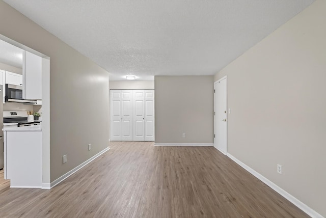 4371 Wilshire Blvd Unit 107, Mound, MN 55364 - unfurnished living room with light wood-type flooring and a textured ceiling