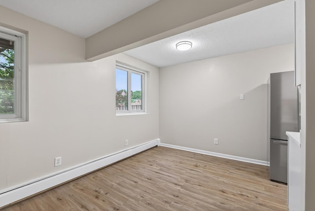 4371 Wilshire Blvd Unit 107, Mound, MN 55364 - empty room featuring baseboard heating and light wood-type flooring