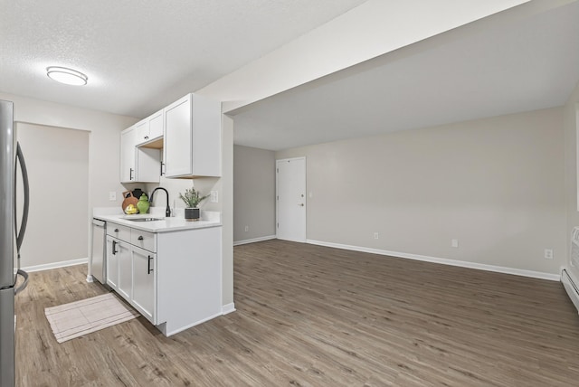 4371 Wilshire Blvd Unit 107, Mound, MN 55364 - kitchen with stainless steel appliances, light countertops, light wood-type flooring, white cabinets, and a textured ceiling