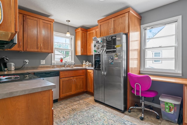 1622 3rd St NE, Rochester, MN 55906 - kitchen featuring appliances with stainless steel finishes, brown cabinets, hanging light fixtures, stone finish floors, and a textured ceiling