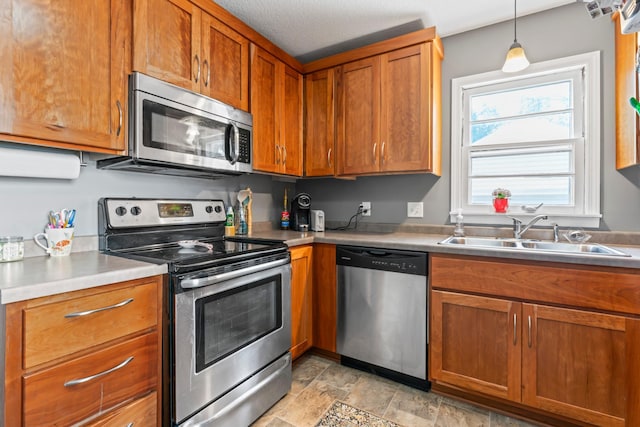 1622 3rd St NE, Rochester, MN 55906 - kitchen with appliances with stainless steel finishes, brown cabinetry, light countertops, and decorative light fixtures