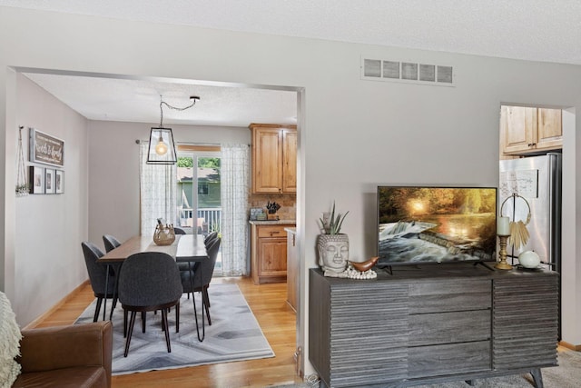 704 Lexington Ave N, New Prague, MN 56071 - dining space featuring light wood finished floors and a textured ceiling