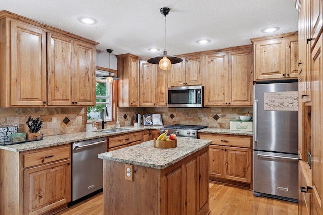 704 Lexington Ave N, New Prague, MN 56071 - kitchen featuring appliances with stainless steel finishes, tasteful backsplash, light wood-style flooring, light stone counters, and a textured ceiling