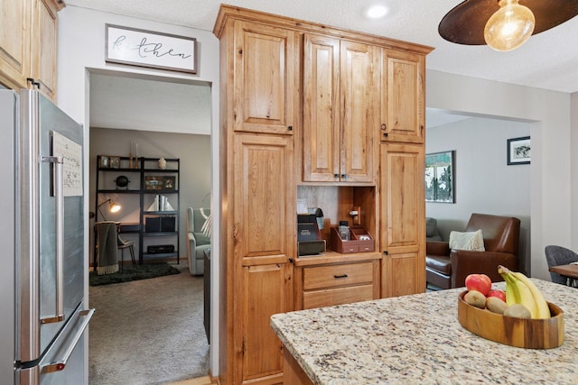 704 Lexington Ave N, New Prague, MN 56071 - kitchen featuring freestanding refrigerator, light colored carpet, light stone countertops, open floor plan, and a textured ceiling