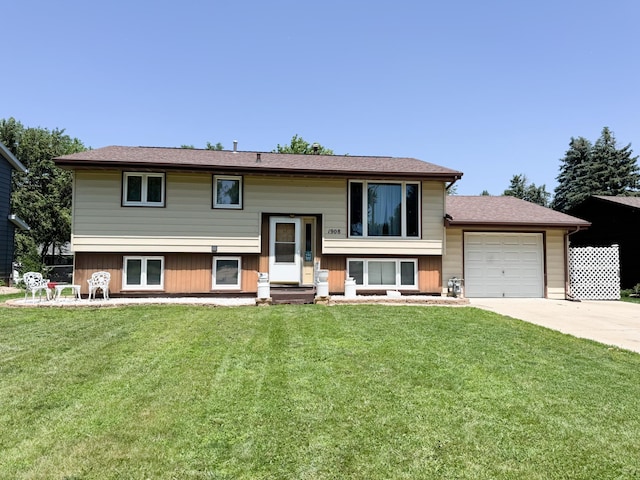 1908 Summit Ave, Worthington, MN 56187 - split foyer home with concrete driveway, a garage, and a front lawn