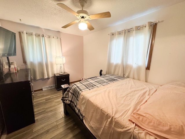 1908 Summit Ave, Worthington, MN 56187 - bedroom featuring dark wood-type flooring, a textured ceiling, and a ceiling fan